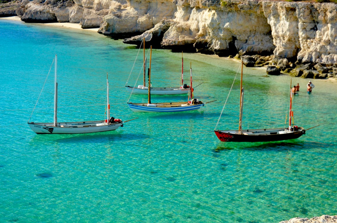 four Drascombe Longboats moored in turquoise water on the Baja coast