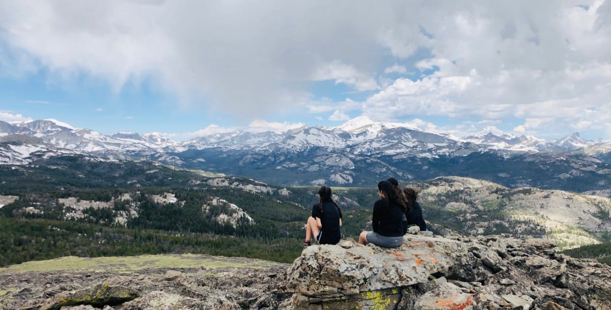 Several NOLS students overlook a mountain landscape