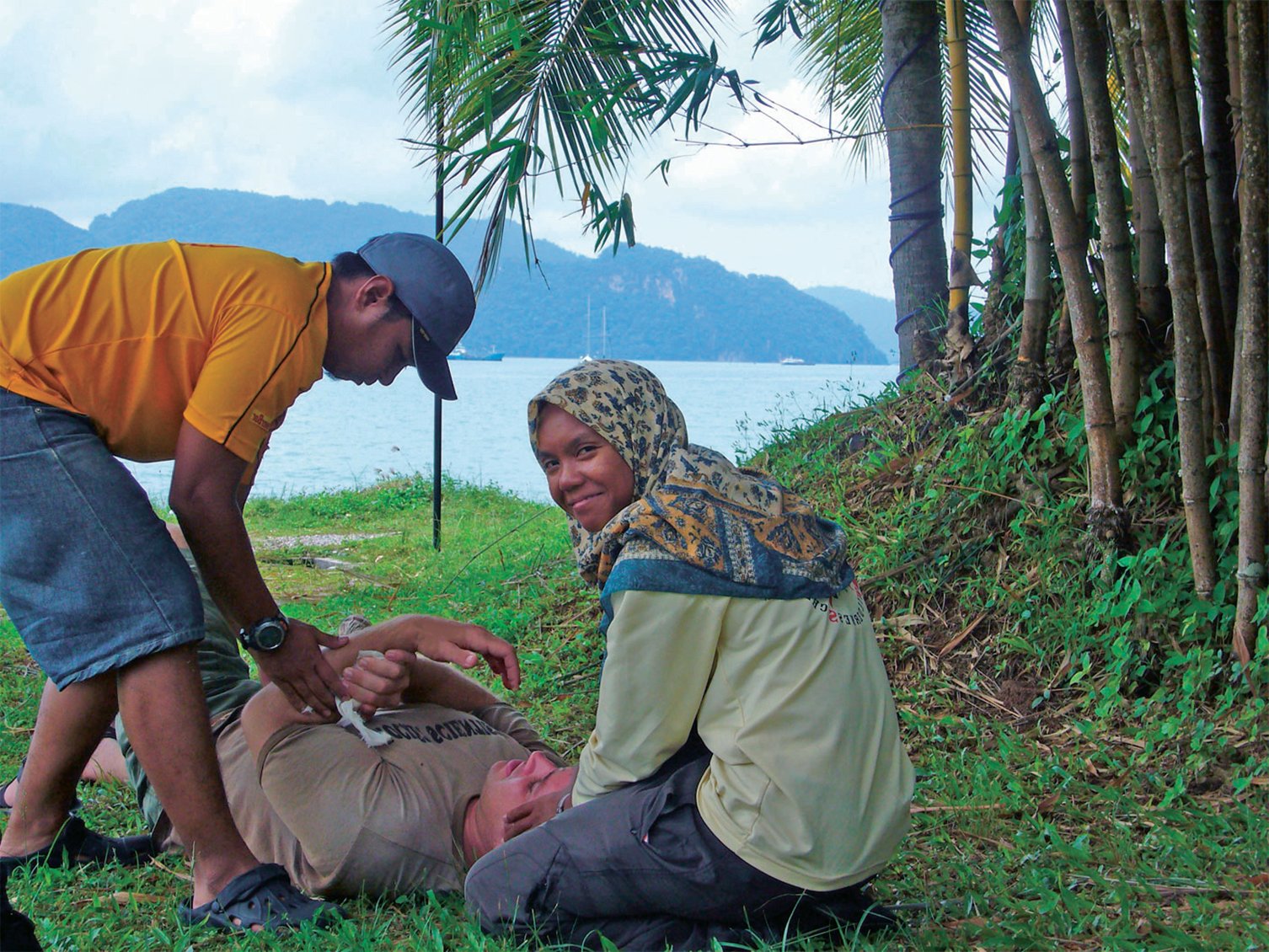 Woman wearing a head scarf and a man practice patient care on a NOLS wilderness medicine course