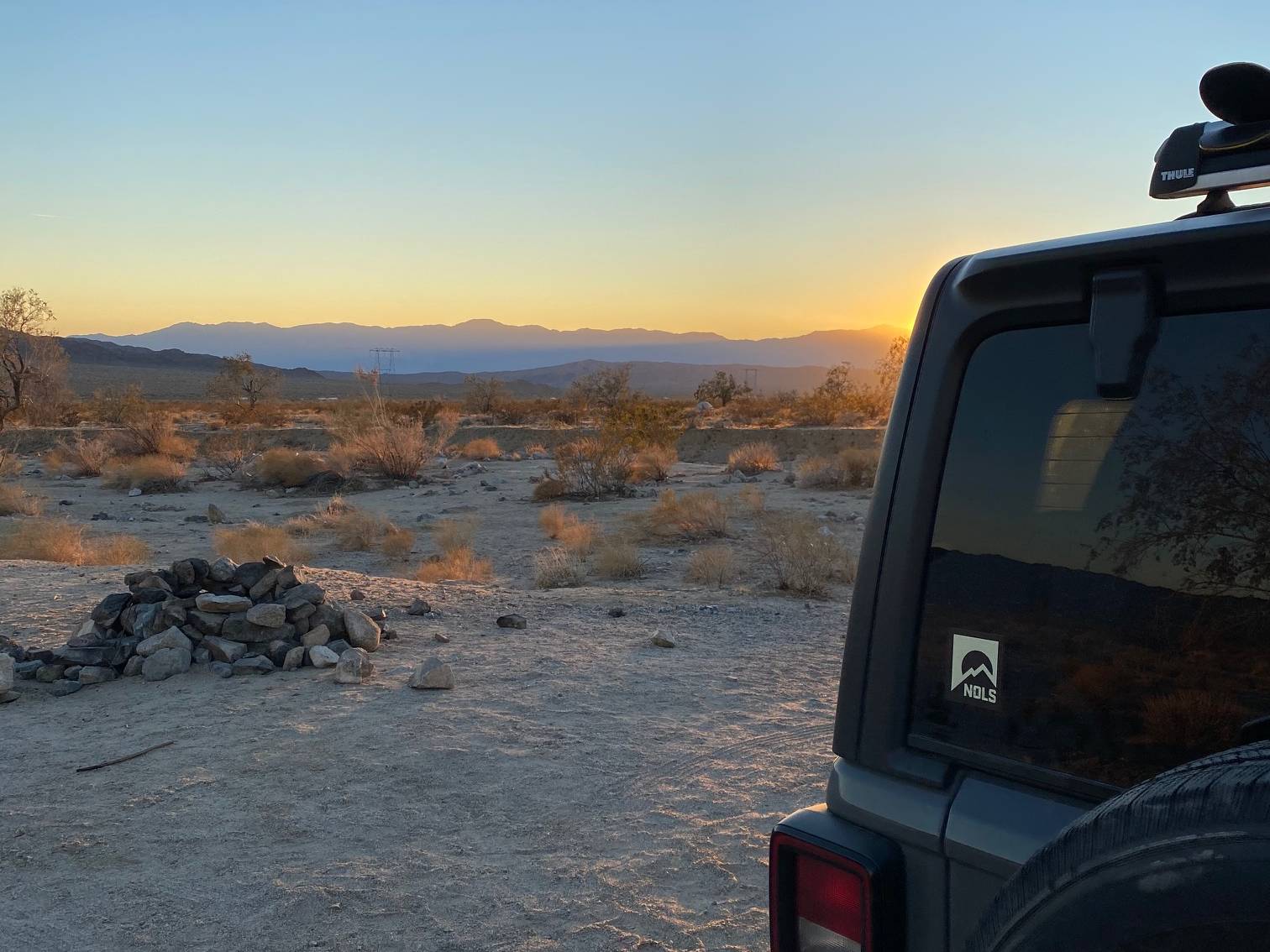 Back hatch of a car in the desert at sunset