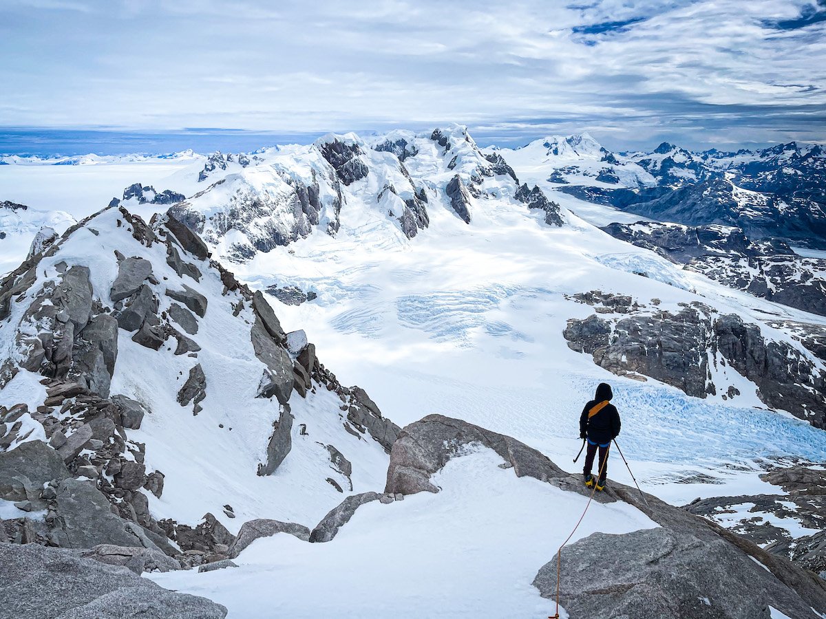 Mountaineer overlooks the descent with a large glacier below