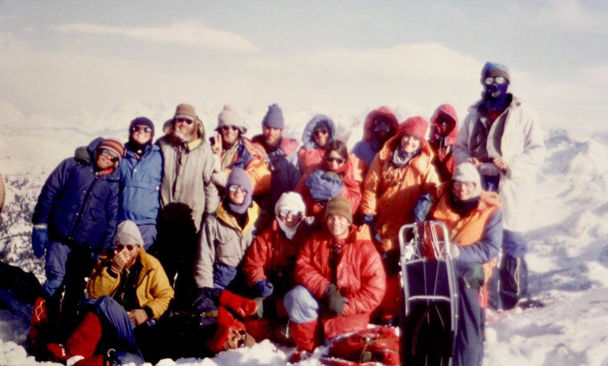 Archival photo of large smiling NOLS group on a mountaineering course