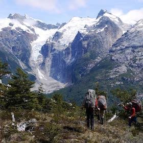 NOLS students backpack in Patagonia, heading toward snow-capped peaks