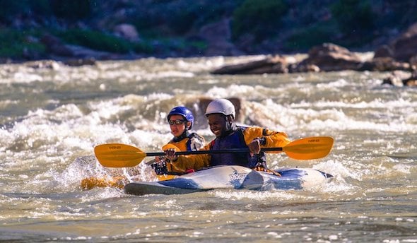two NOLS participants whitewater kayaking