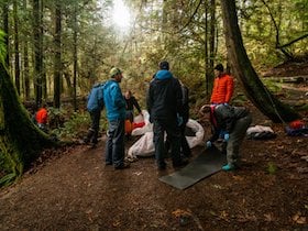 NOLS Wilderness Medicine students participate in a scenario in the woods