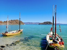 two Drascombe Longboats anchored in shallow turquoise water in Baja California