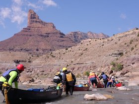NOLS students navigate canoes through a rapid