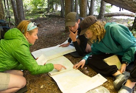 NOLS instructor and two students consult a map together in the Pacific Northwest