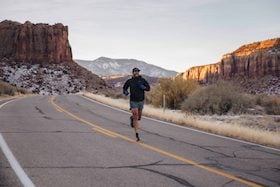 Jorge Moreno runs on an empty road as part of a weekend run across Bears Ears and Escalante National Monuments