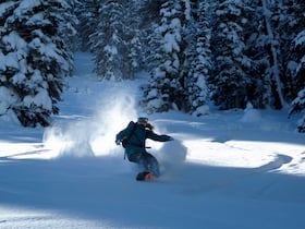 NOLS student snowboards fresh powder in the backcountry
