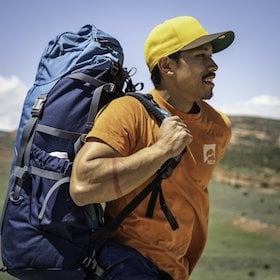 smiling backpacker with NOLS pack and t-shirt