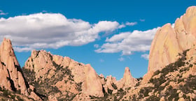 red rock formations with blue sky and clouds above at Cochise Stronghold