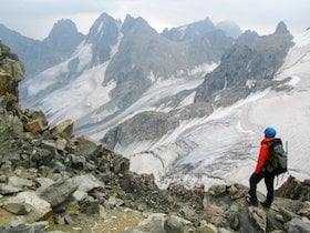 NOLS mountaineering participant looks toward snowy crags in the Wind River Range