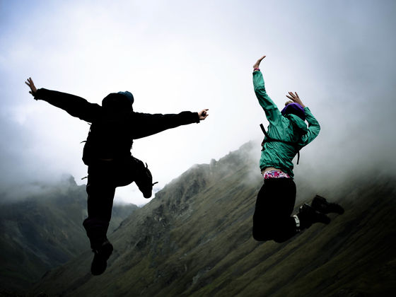 two NOLS students leap into the air in the fog in Alaska's mountains