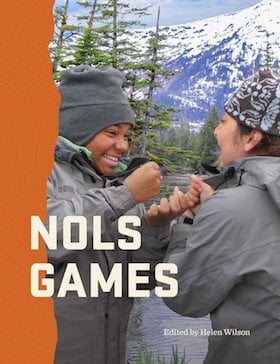 cover of NOLS Games book with smiling students playing game