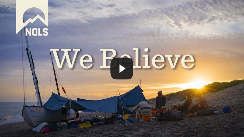 NOLS video with image of tents on a beach at sunset overlaid by We Believe text