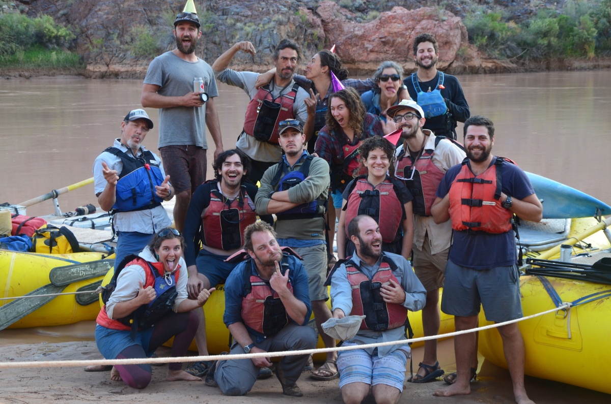Group photo in front of rafts on a river
