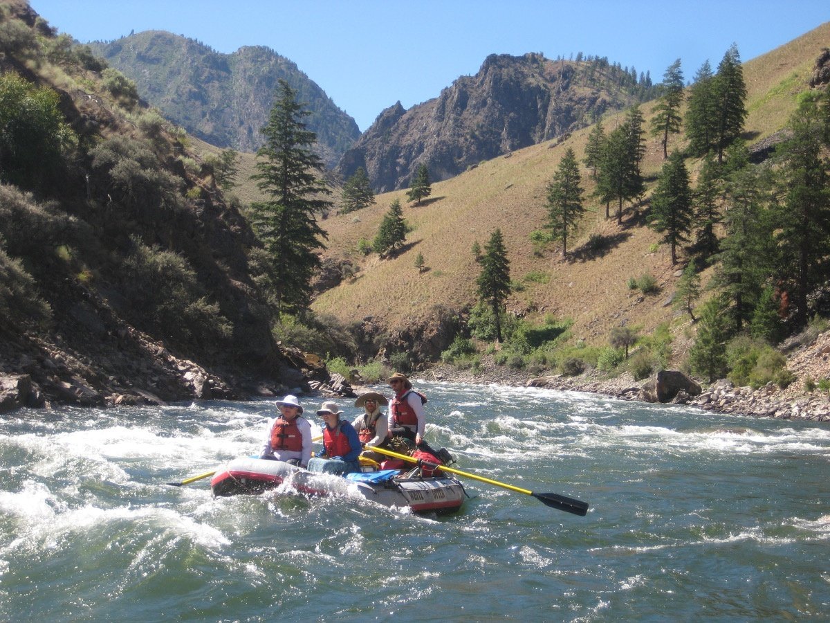 Four family members paddle a raft on whitewater in the Salmon River