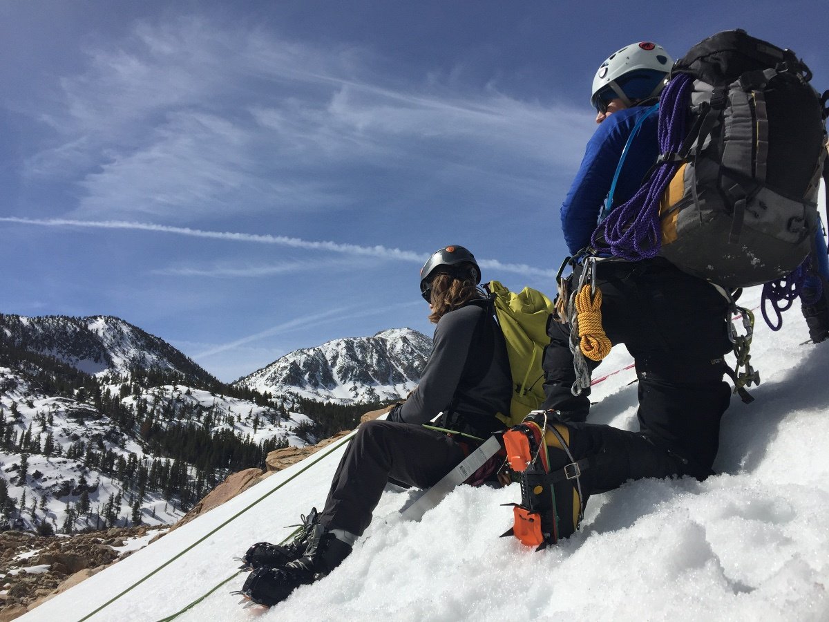 Students sit on snow and rest while mountaineering