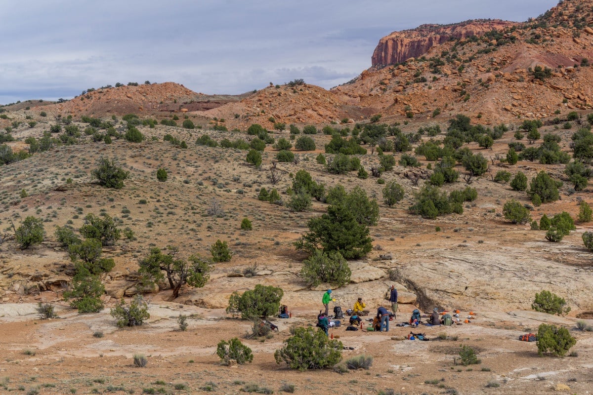 Group of students circles up at camp in Utah's canyonlands