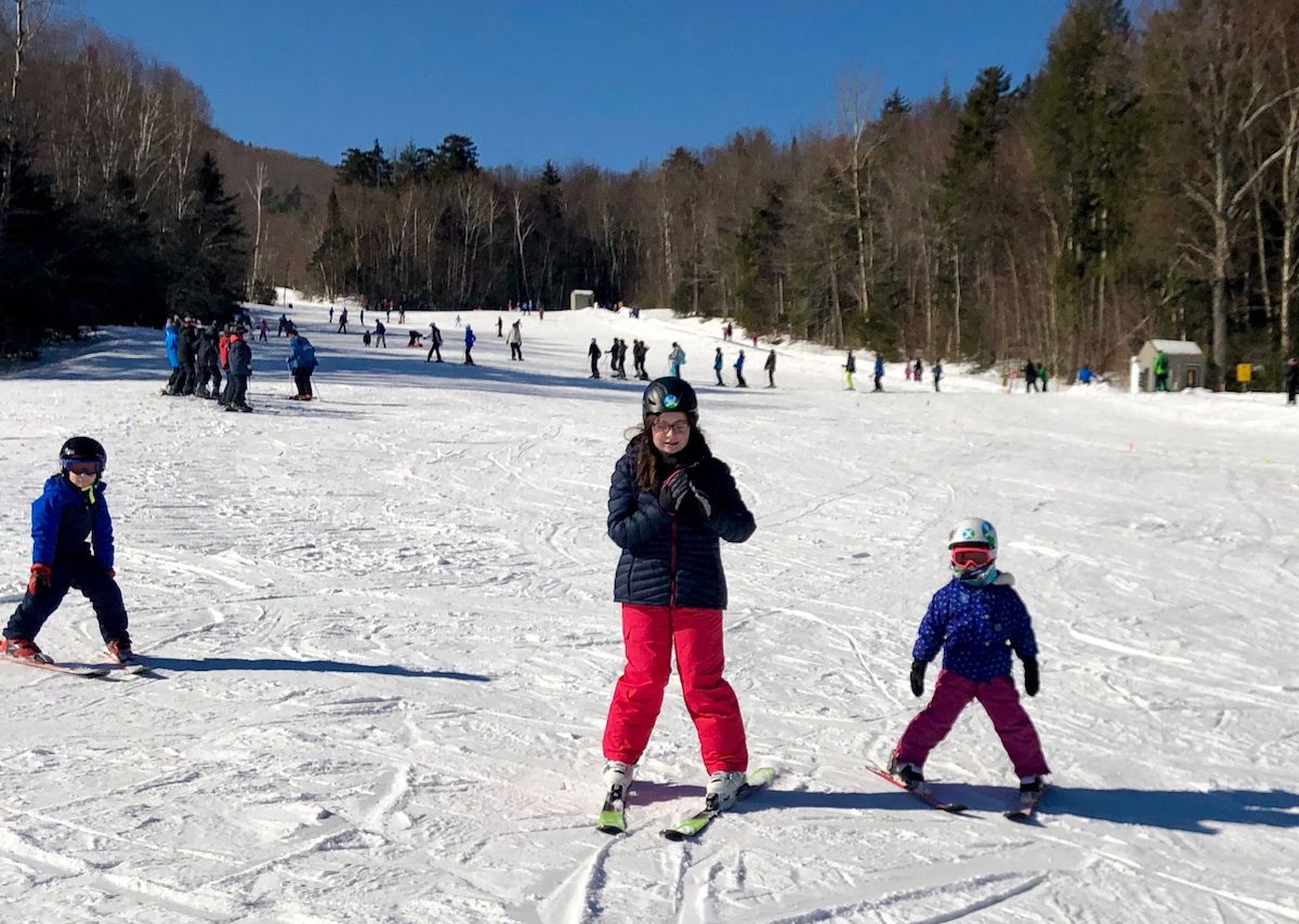 three children downhill skiing