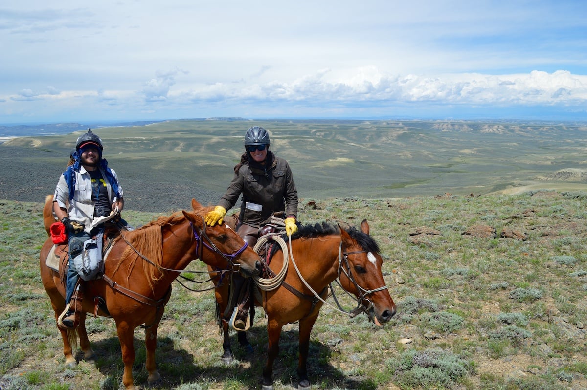 two NOLS participants on horseback smile at the camera