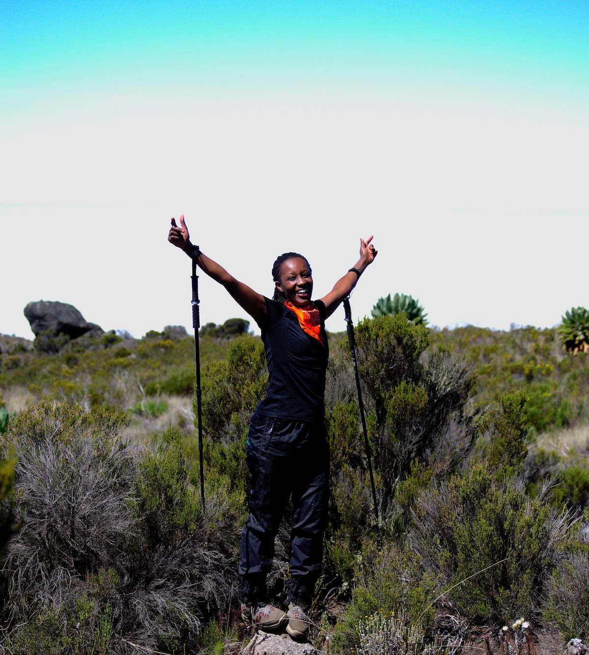 Carol Wanjiru smiles with trekking poles on the trail