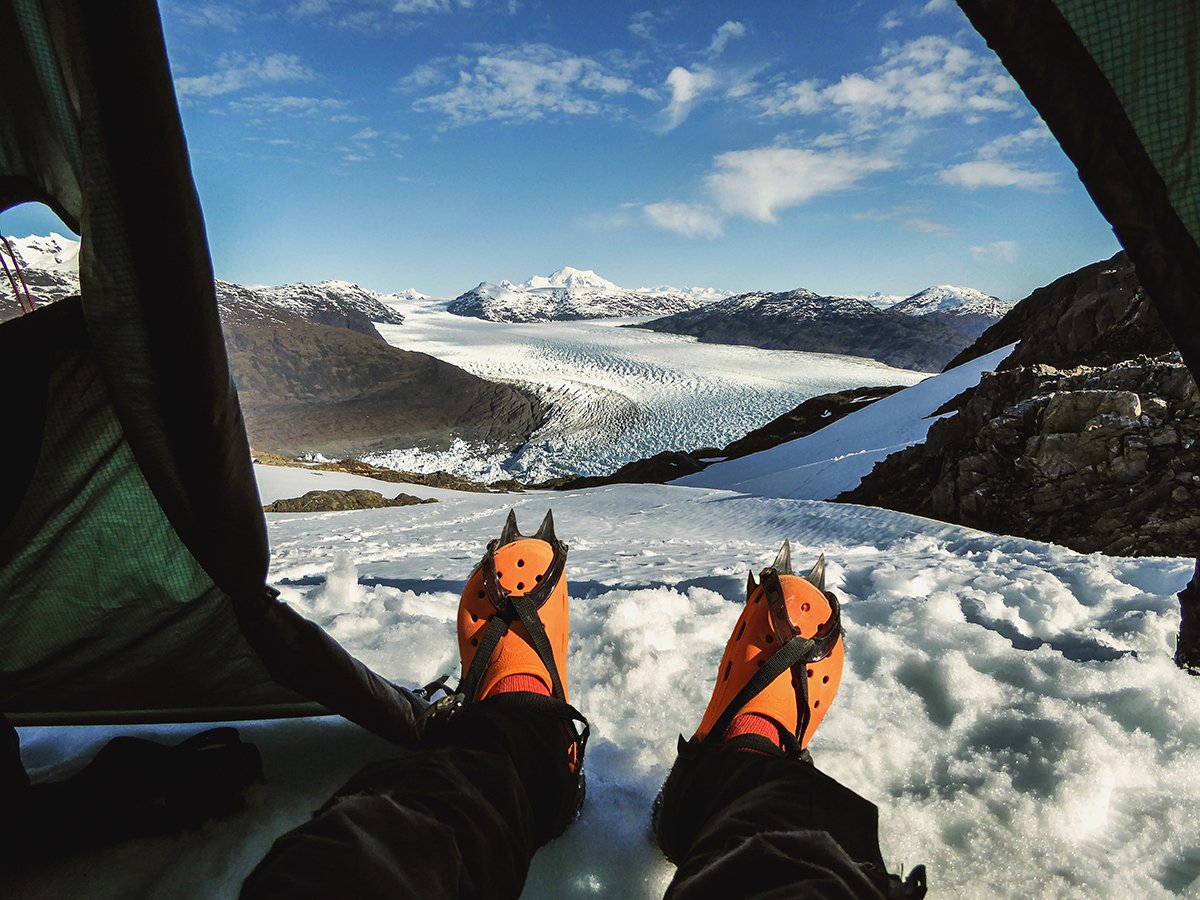 Spoof NOLS gear: camp shoes with crampons with glacier background