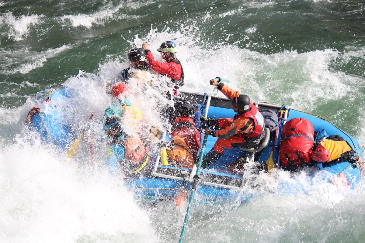 Group of people raft through a rapid