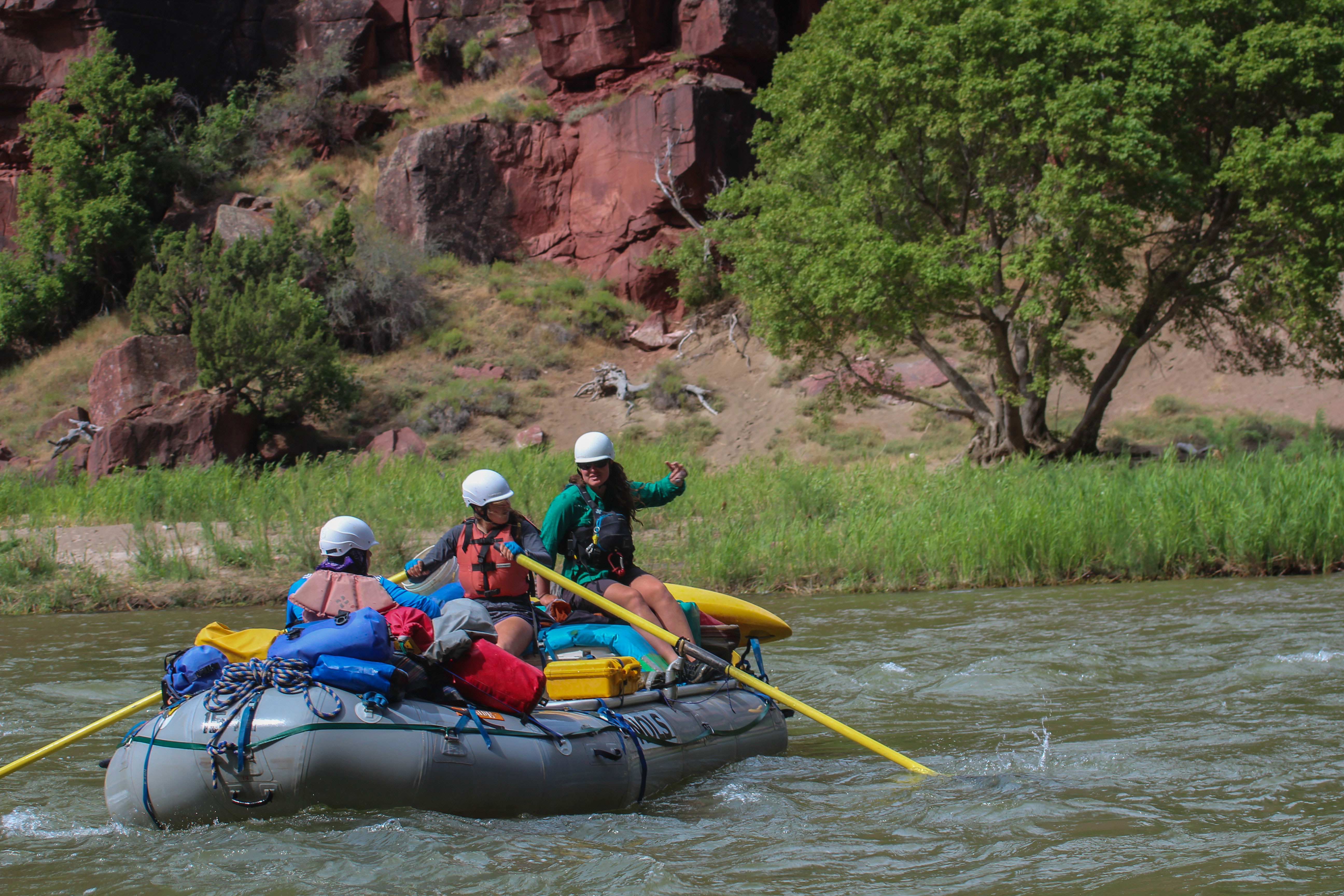 Students steer a raft down the river on a NOLS course
