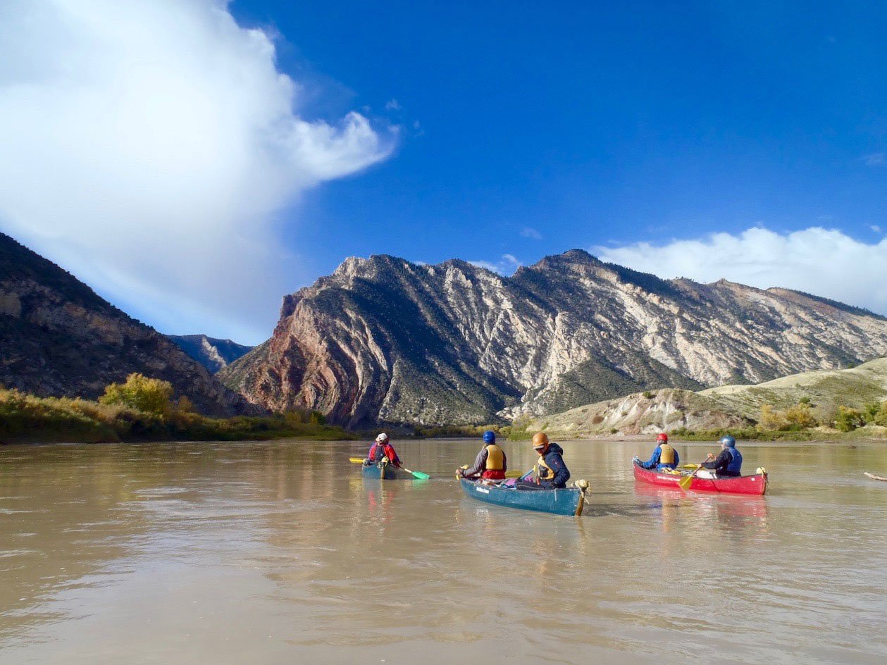 Students canoe on a river in the desert