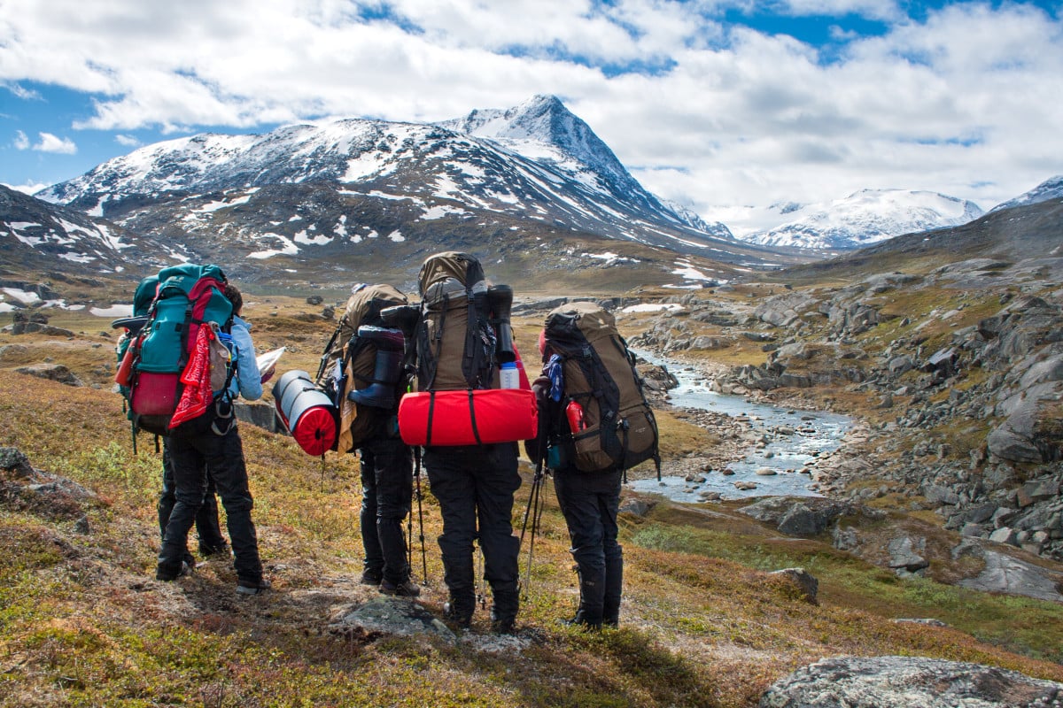 Backpacking group overlooking river valley in Scandinavia