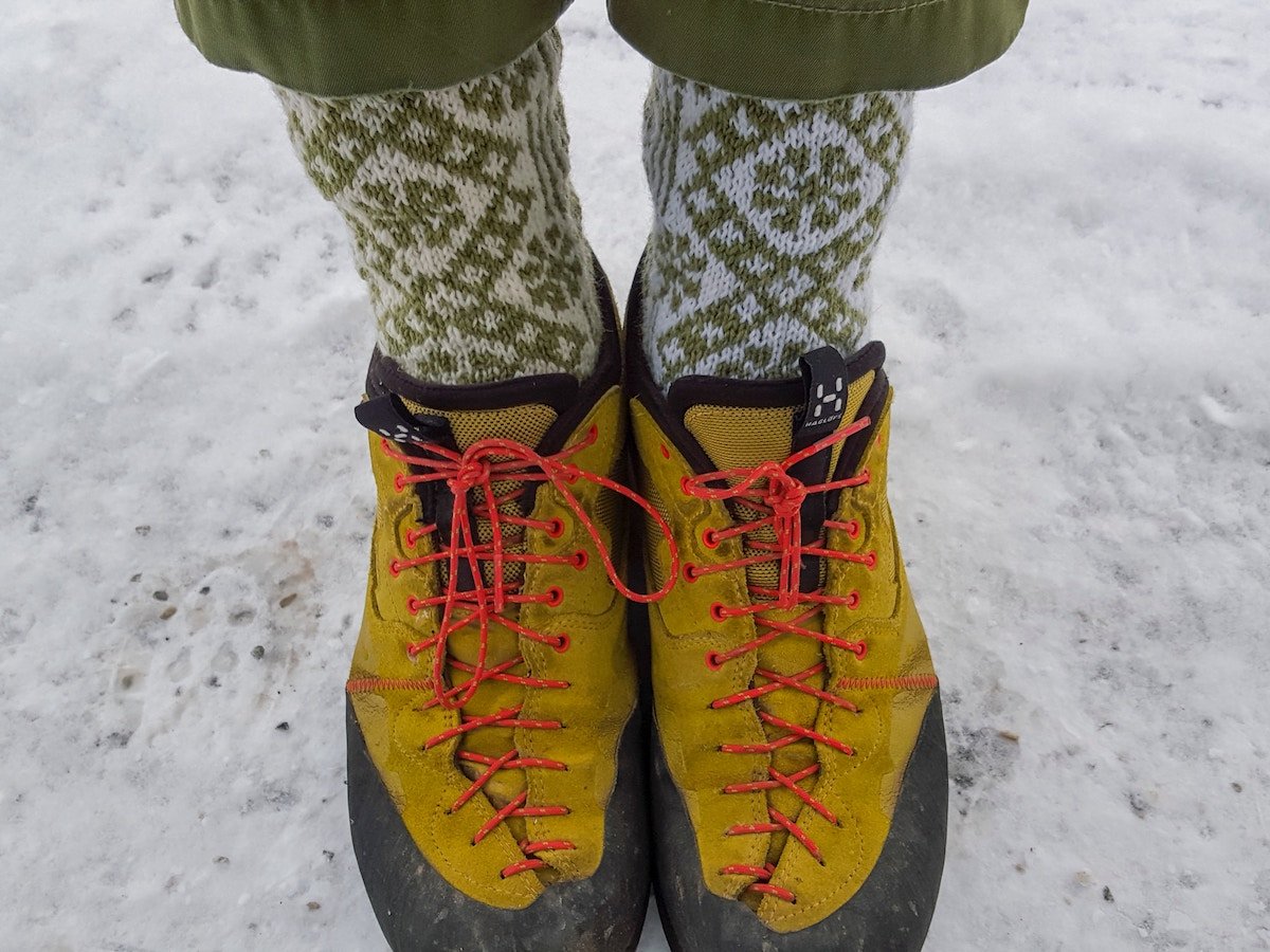 feet in yellow shoes with neon laces and green and white socks with snowflake pattern