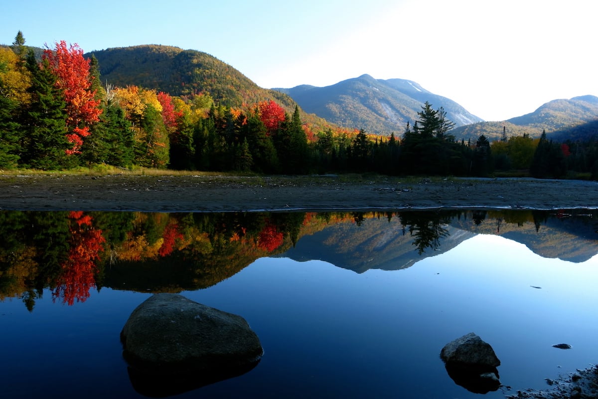 fall foliage in the Adirondacks reflected in a glassy mountain lake