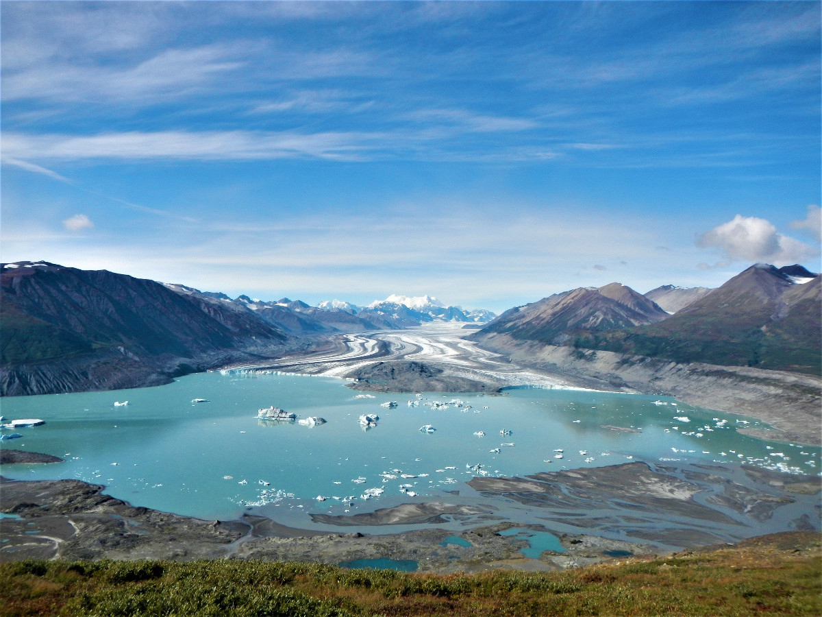 turquoise glacial lake as viewed from above with mountains surrounding