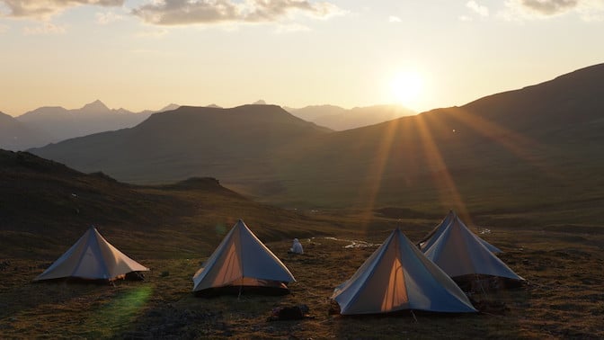 A group of four tents at sunrise