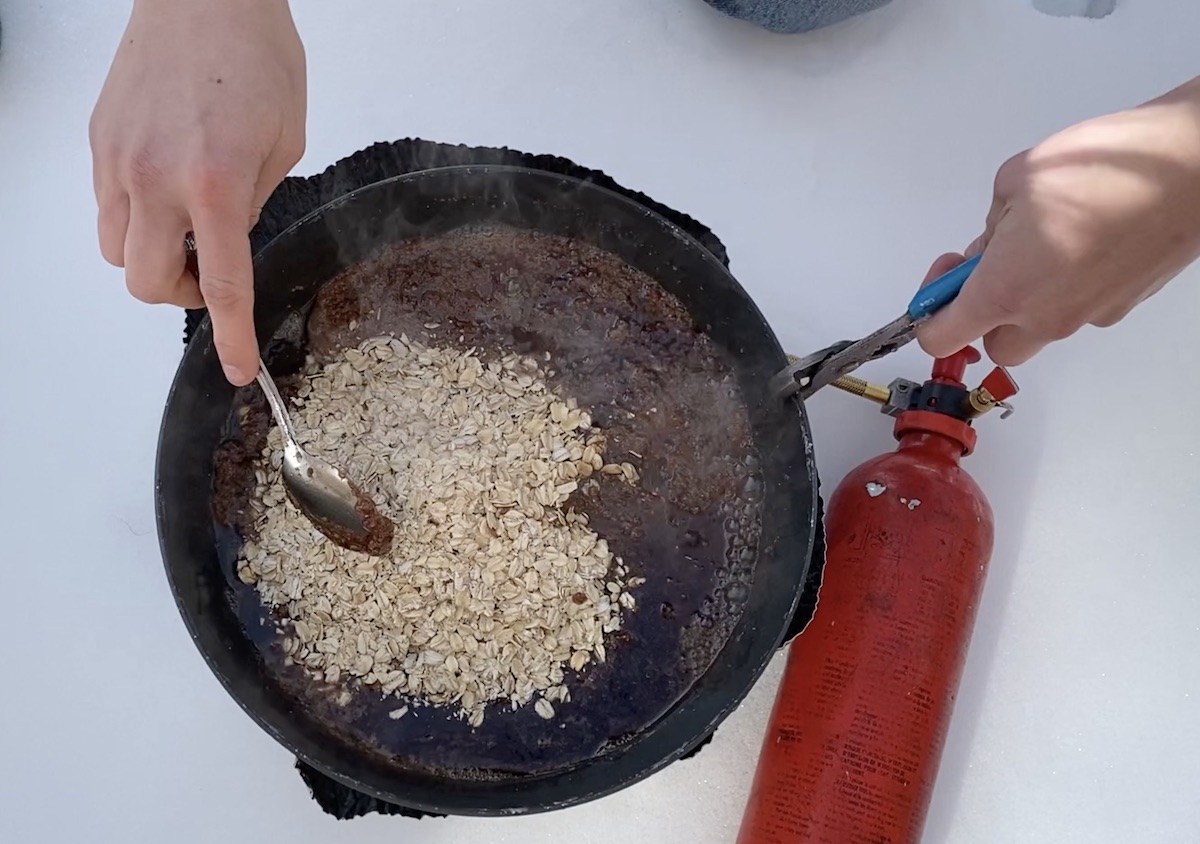 sing a spoon to mix oats into no-bake cookie batter on a camp stove