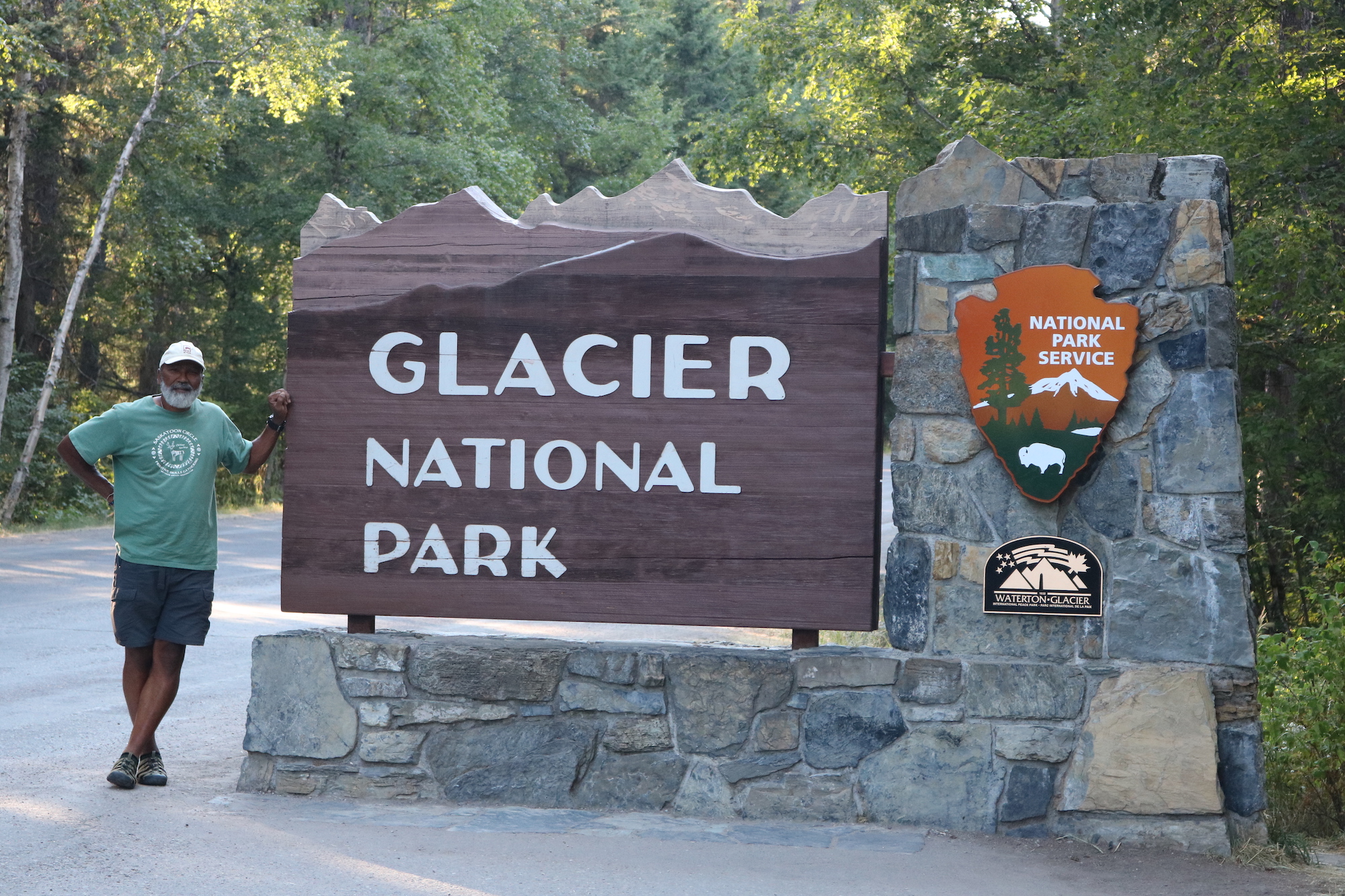 Carter McBride at the entrance sign to Glacier National Park