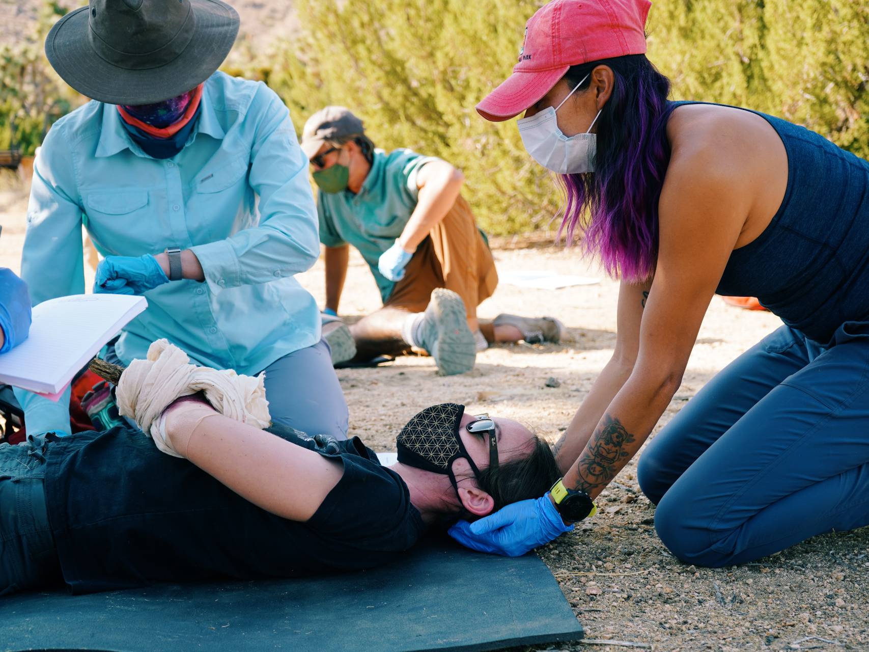 A group of three practices taking a pulse in a mock scenario