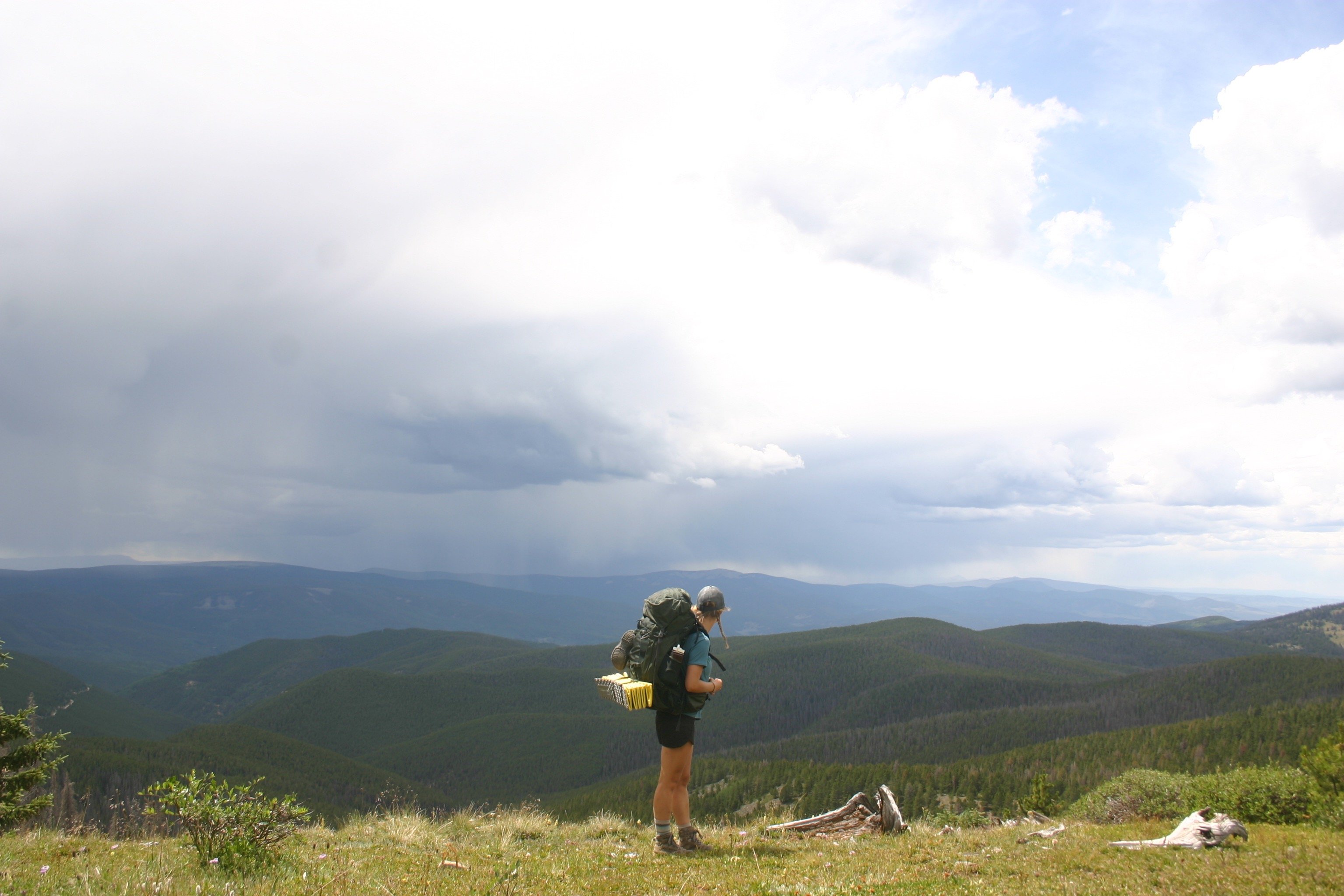 Kenna Kuhn overlooks a mountain valley while backpacking
