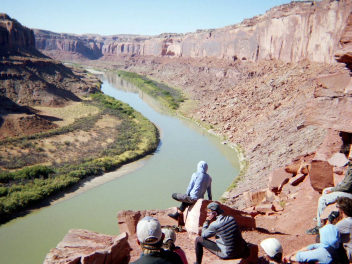 NOLS students overlook a river in a desert canyon
