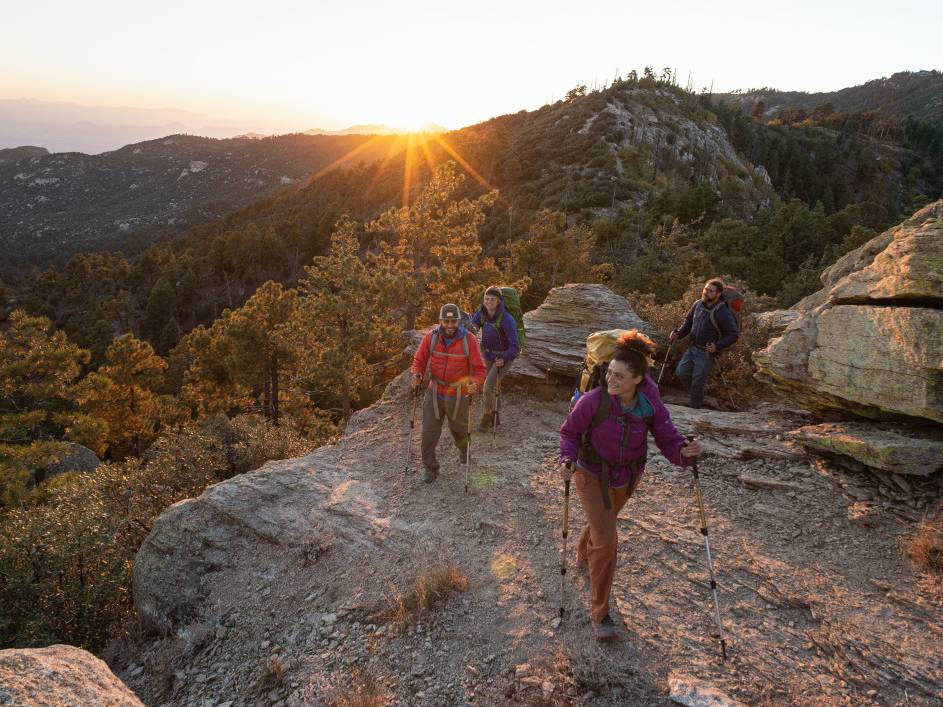 Hikers ascend a sandy ridge