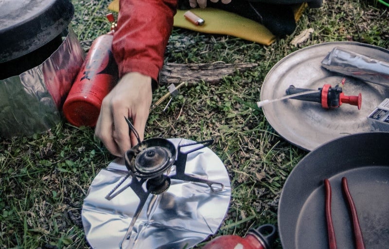 Close up of a hand starting a whisperlite stove