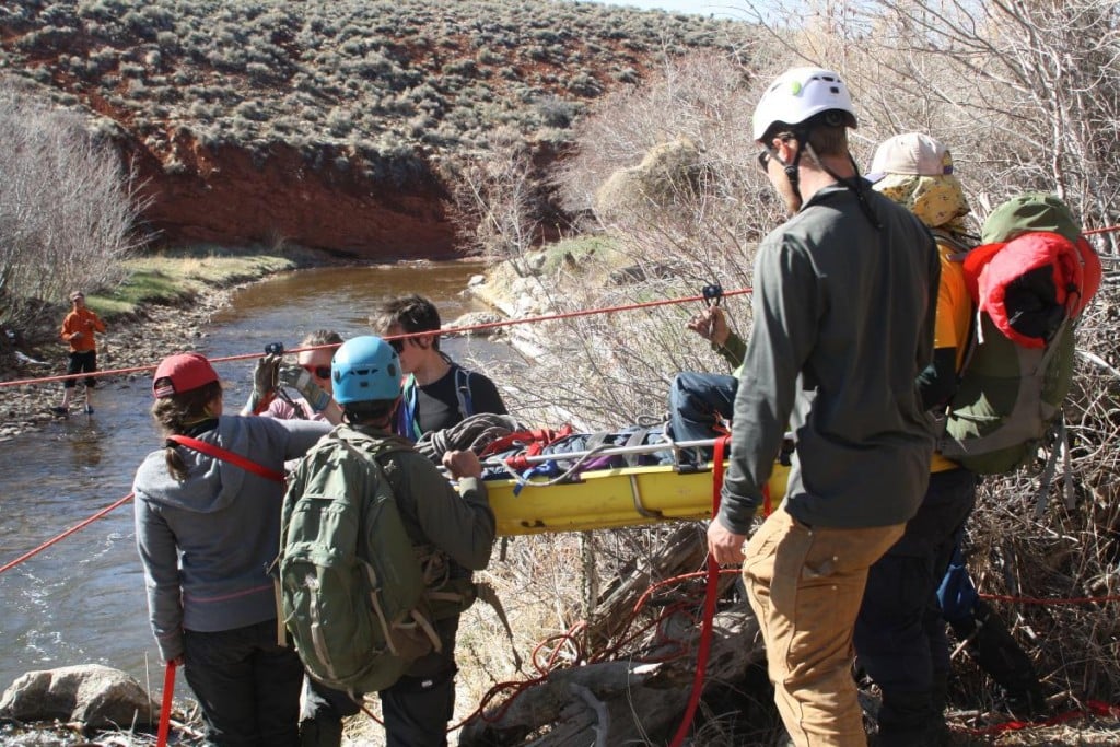 NOLS wilderness medicine students participate in a scenario by the river at the Wyss Campus in Lander