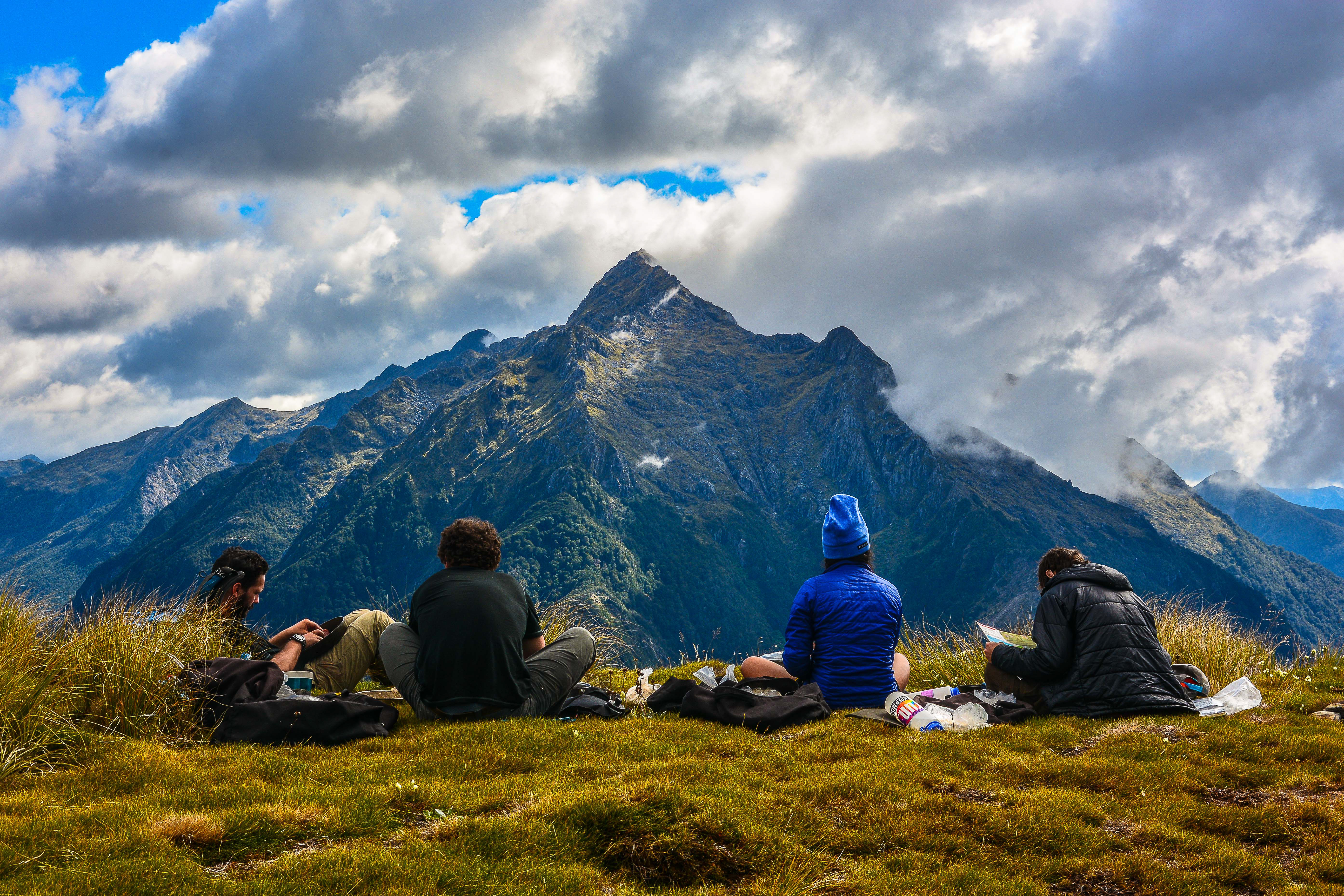 Four students preparing a meal while overlooking a New Zealand mountain range