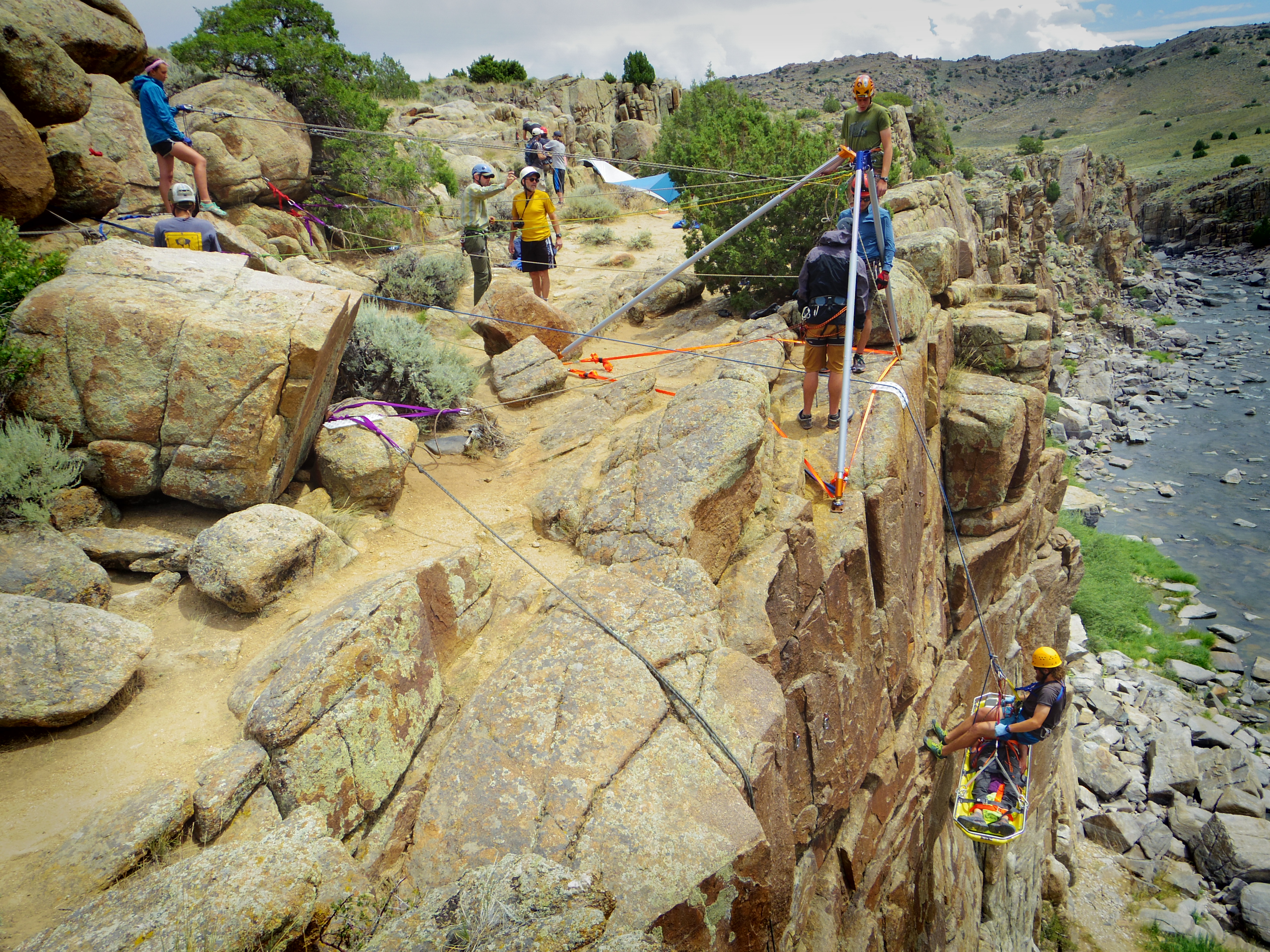 Patient immobilized in a liter being lowered down a vertical face on a Wilderness Medicine and Rescue Semester